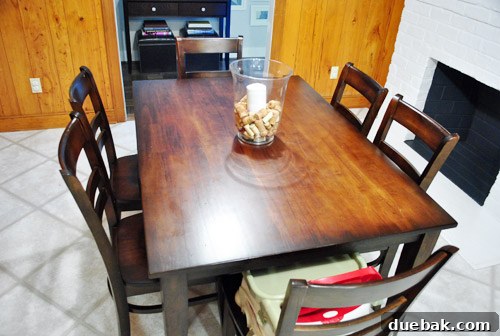 The same kitchen table now mostly clear, with just a few essentials, showing a transformation.