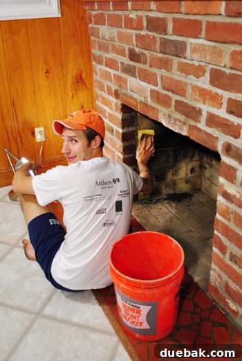 Person cleaning the inside of the dirty fireplace