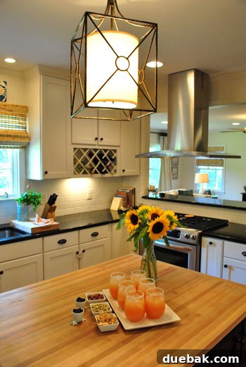 Inside a Stunning North Carolina Home 4 Transformed open-concept kitchen with an oversized Troy Lighting lantern over the island and butcher block countertops