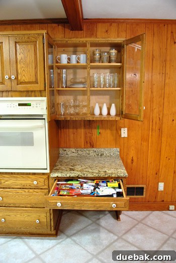 Overflowing double-wide kitchen junk drawer filled with various household items, signaling a need for organization.