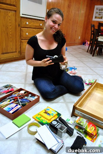 Person sorting through items from a junk drawer spread out on the floor, making 'keep', 'store', and 'discard' piles.