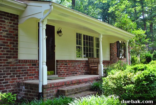 Wooden bench on a stark porch, highlighting the lack of decor