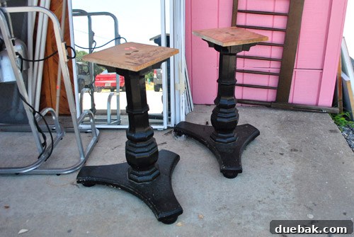 Two chunky wooden pedestal bases and a tabletop, ideal for DIY tables