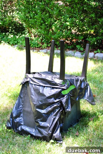 Chair legs being spray painted upside down on a recycling bin