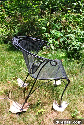 Patio chairs and table laid out on old magazines and cardboard for spray painting