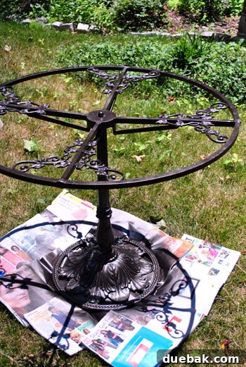 Person spray painting a patio chair outdoors