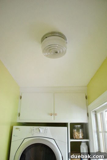 Original light fixture being removed from ceiling