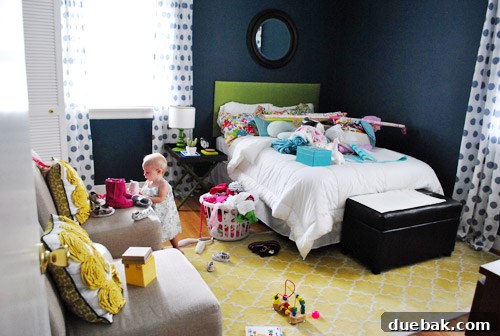 Nursery rug rolled back to protect from paint splashes, indicating a home renovation project