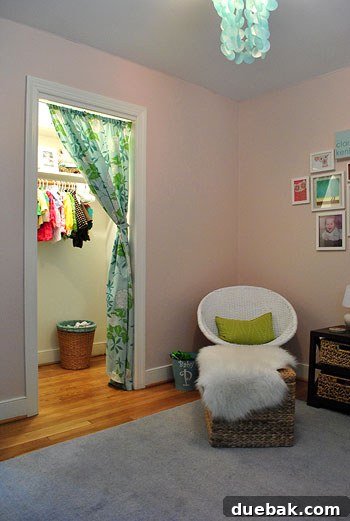 Clara's nursery with soft gray-pink walls, showing floral curtains at the closet entrance