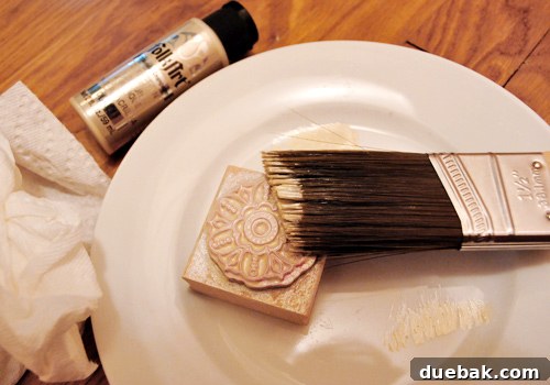 Close-up of metallic craft paint and a paintbrush, ready for the hand-stamping project