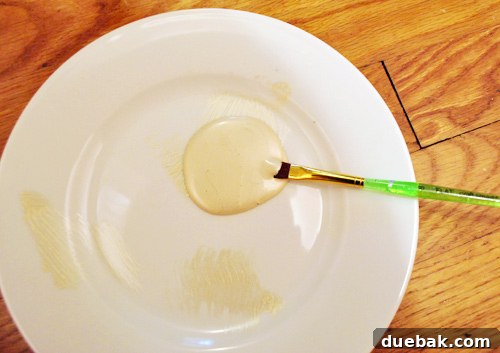 A wider paintbrush and metallic craft paint, prepared for freehand pattern experimentation on the wall