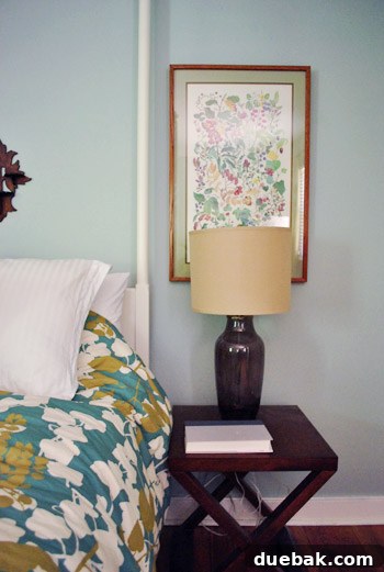 From Drab to Fab: Spray Paint Frame Makeover 6 Master bedroom with a resin ram head above the bed, flanked by dark candle holders and warm wood frames