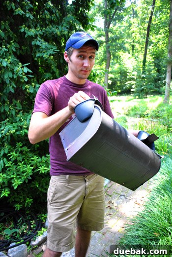 John carrying the hot, newly spray-painted mailbox with protective pot holders