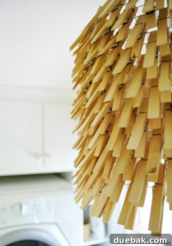 Clothespin chandelier showing natural wood pins against the wall