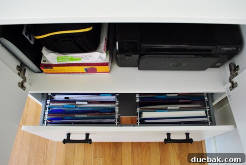 Clever Printer Concealment Ideas 14 File cabinet drawers opened to reveal a neat arrangement of colorful hanging files, enhancing organization and visual appeal.
