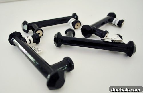 Clever Printer Concealment Ideas 3 Black glass cabinet handles laid out on a clean surface, highlighting their elegant design and reflective quality.