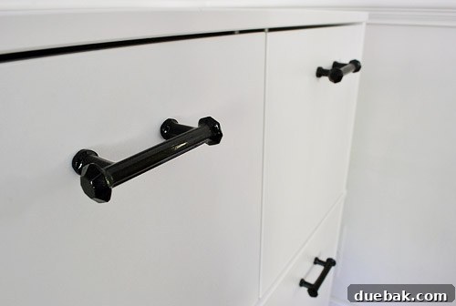 Clever Printer Concealment Ideas 9 Two newly installed black glass cabinet handles on the pristine white IKEA Effektiv cabinet, showcasing their perfect alignment.
