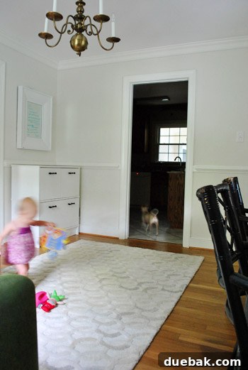 Corner of the home office with a file cabinet and an ottoman filled with toys.