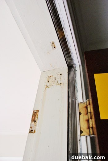 Close-up of a front door undergoing preparation, highlighting the smooth texture after sanding and spackling.