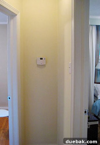 Narrow hallway in the first house, decorated with a gallery wall