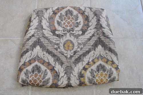Upholstery fabric being aligned and centered on the rocking chair seat