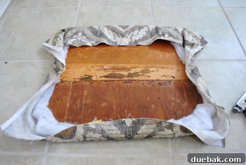 Close-up of the underside of the seat, showing initial staples for centering fabric