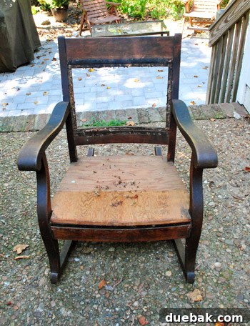 Close-up of the rocking chair frame, showing staples and old fabric