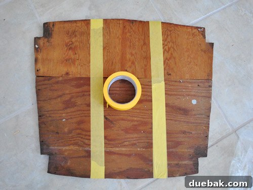 Two wooden seat pieces taped together for upholstery preparation