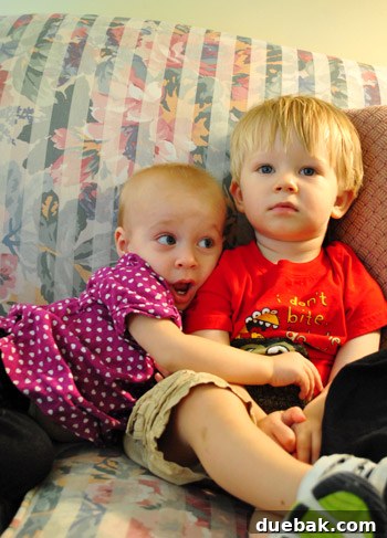 Child in cousin's arms, finding comfort after the storm at a relative's house with power