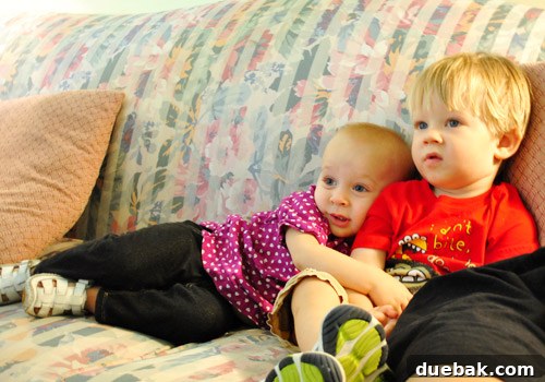 Two children happily watching a video together, a moment of normalcy after the storm