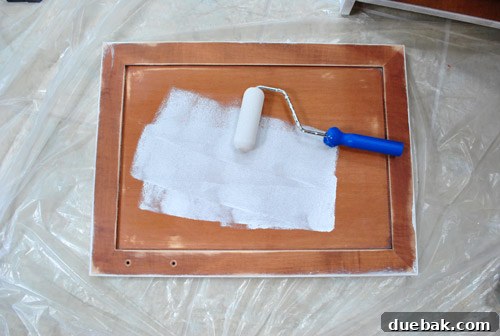 Cabinet Painting Prep for a Perfect Finish 11 Applying Kilz Clean Start primer to cabinet doors with a foam roller