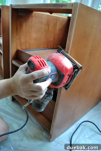 Cabinet Painting Prep for a Perfect Finish 9 Sanding cabinet frames indoors with a power sander
