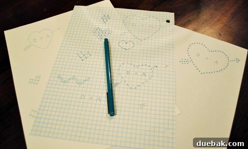 Sketches of cross-stitch designs on graph paper