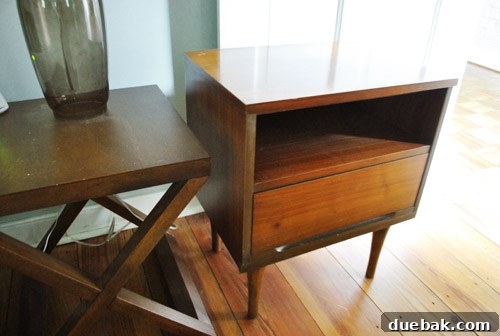 Before and after view of a bedroom nightstand showing a small, low table cluttered with items next to a bed, highlighting the need for functional storage.