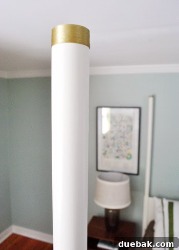 Close-up of a bedpost adorned with a green-gold ribbon, secured with tape, demonstrating a temporary bed decoration idea.