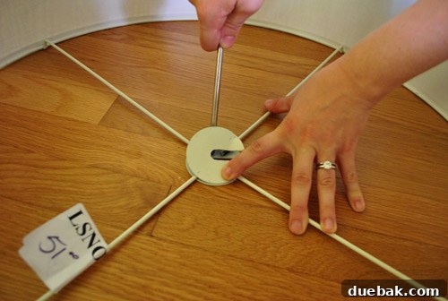 Revitalize Your Old Chandelier With Paint and a Shade Swap 12 Sherry prying off the metal attachment on the drum shade