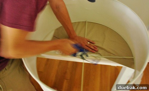 Revitalize Your Old Chandelier With Paint and a Shade Swap 14 Person using a hacksaw to remove part of the drum shade's frame