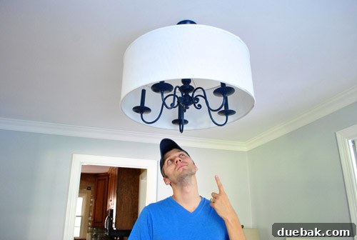Revitalize Your Old Chandelier With Paint and a Shade Swap 26 Person standing comfortably under the raised chandelier