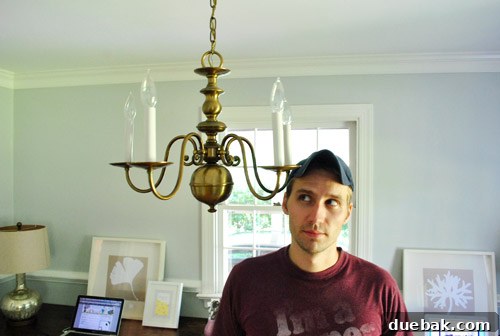 Revitalize Your Old Chandelier With Paint and a Shade Swap 4 Person comically hitting head on low-hanging chandelier