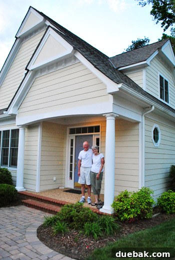 My parents smiling on moving day in front of their new house with a lavender door.
