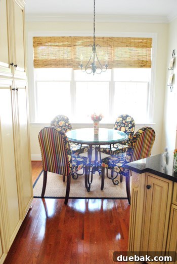 Bright breakfast nook with colorful chairs and a new chandelier.