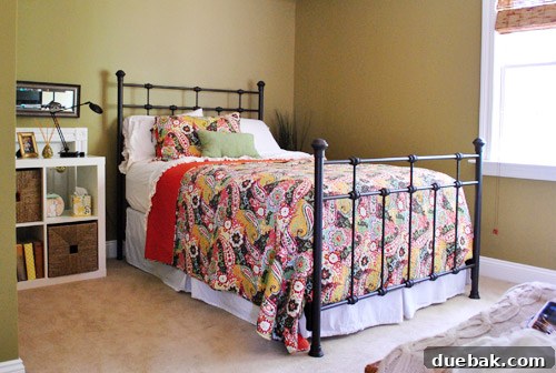Guest bedroom with a warm paint color and a stylish bed frame from Ballard Designs.