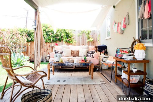 Inviting outdoor lounge area on Jaime's deck with a daybed and colorful cushions under a canopy.