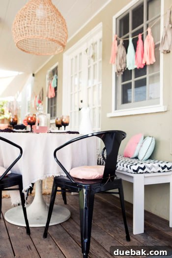 Jaime's chic outdoor dining area with a chevron bench cushion and hanging fabric garlands.