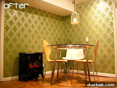 The finished dining nook with a striking green stenciled wall, table, and chairs