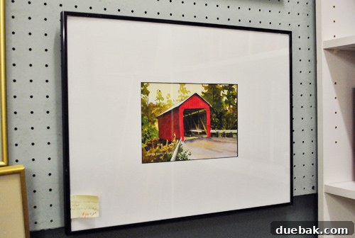 Quaint watercolor painting of a covered bridge