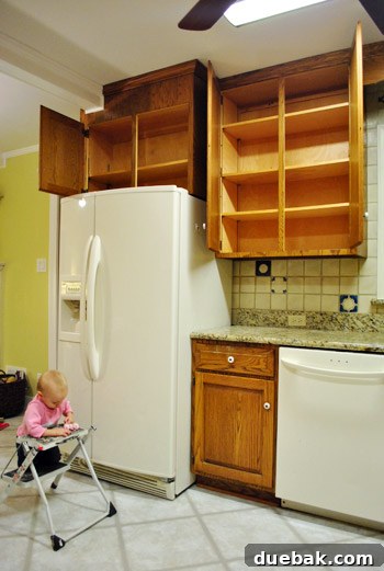 Clara helping with kitchen demolition, sitting on a step stool