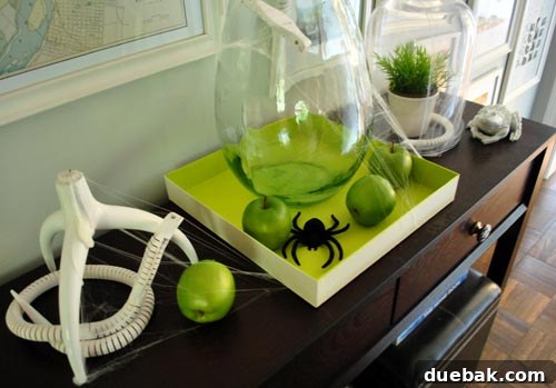 Crafting Halloween's Creepy Crawlies: Spiders and Snakes 5 Close-up of Halloween decorations on a console table, showcasing faux apples and spiderwebs