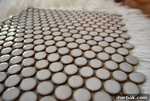 Our Kitchen's Penny Tile Backsplash The Perfect Pick 12 Tile sample close up on ottoman
