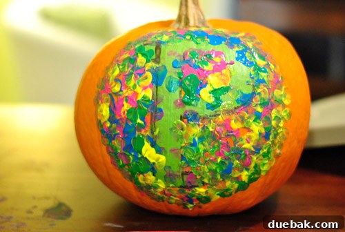 Sherry painting the large pumpkin with a rough circle around the P monogram